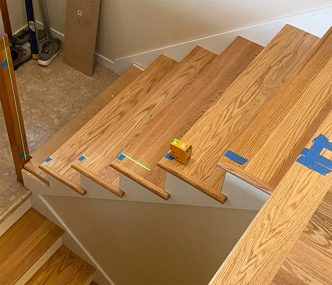 Instalación de piso de núcleo rígido pegado en una escalera, con la nariz de escalón colocada sobre la huella.