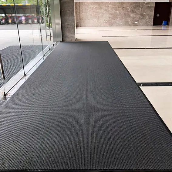 Tapete de entrada comercial de varios pasos en un vestíbulo para capturar humedad y arenilla.